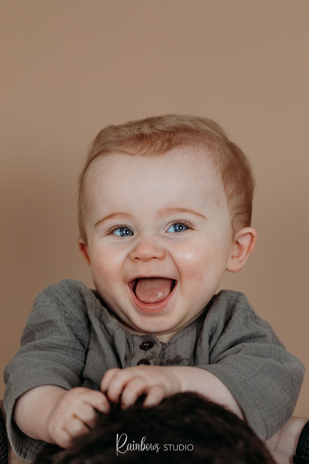 Een uiterst vrolijke baby on de nek van zijn papa.
