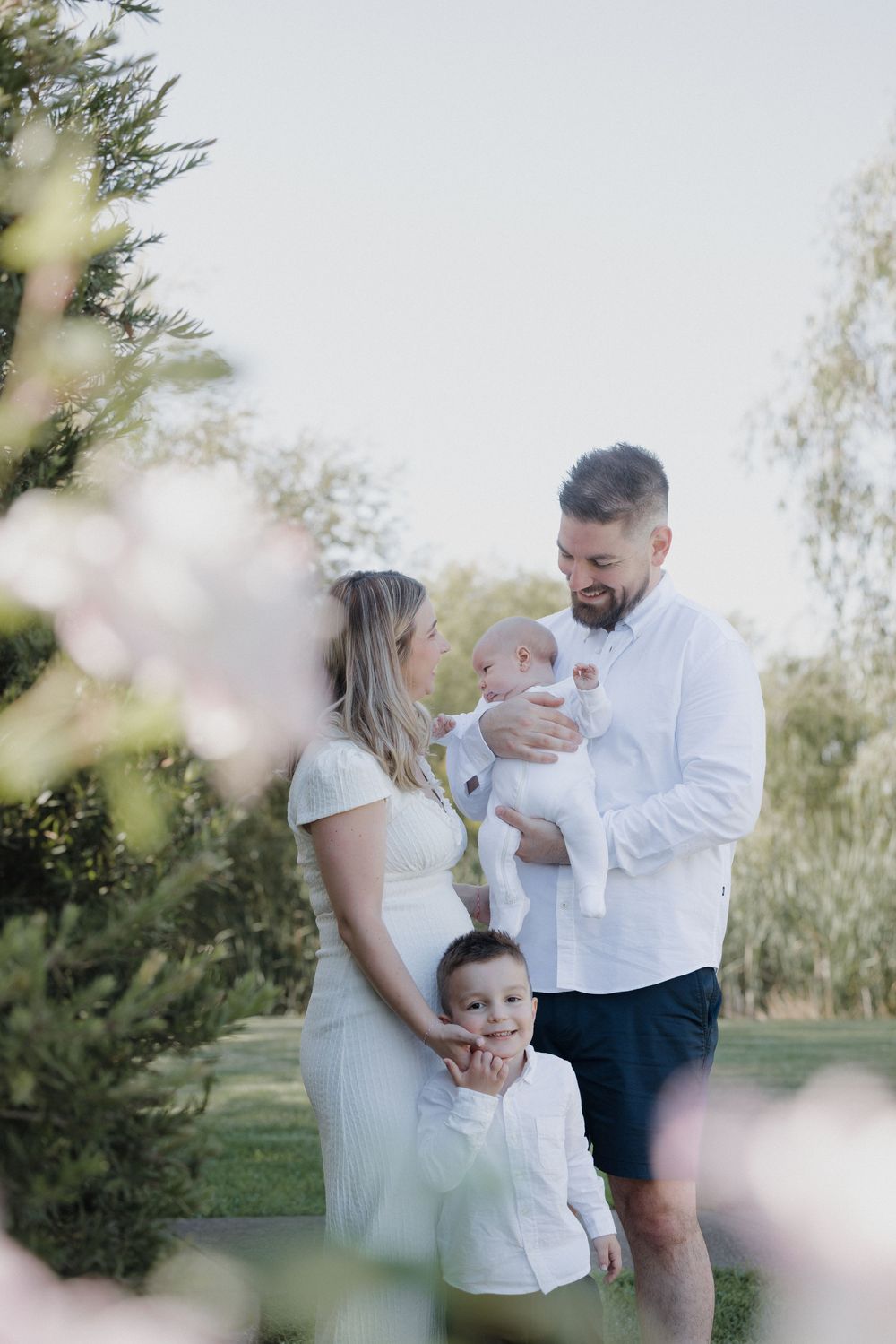A couple shares tender moments in a garden setting with soft lighting and blurred floral elements in the foreground. location shepparton