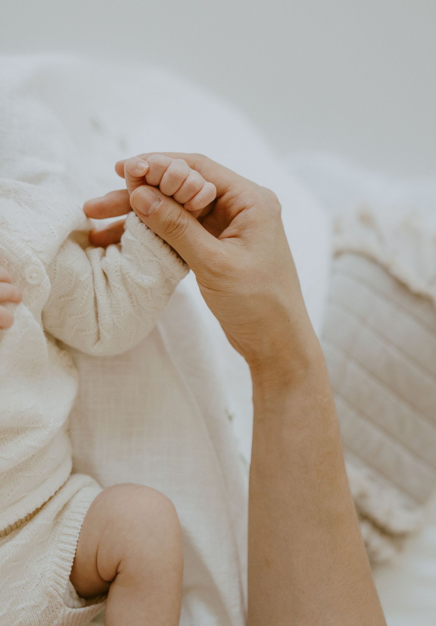 Close-up shot of gentle hands touching soft white fabric.