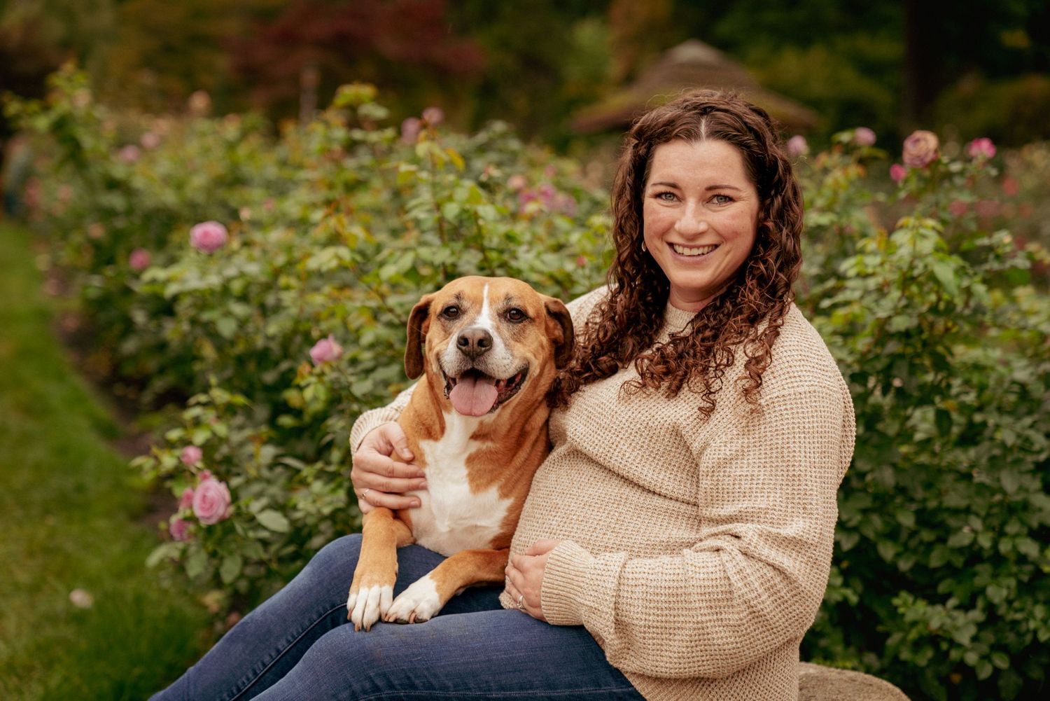 Pregnant woman with dog at Portland rose garden, fall maternity session in the Pacific Northwest.