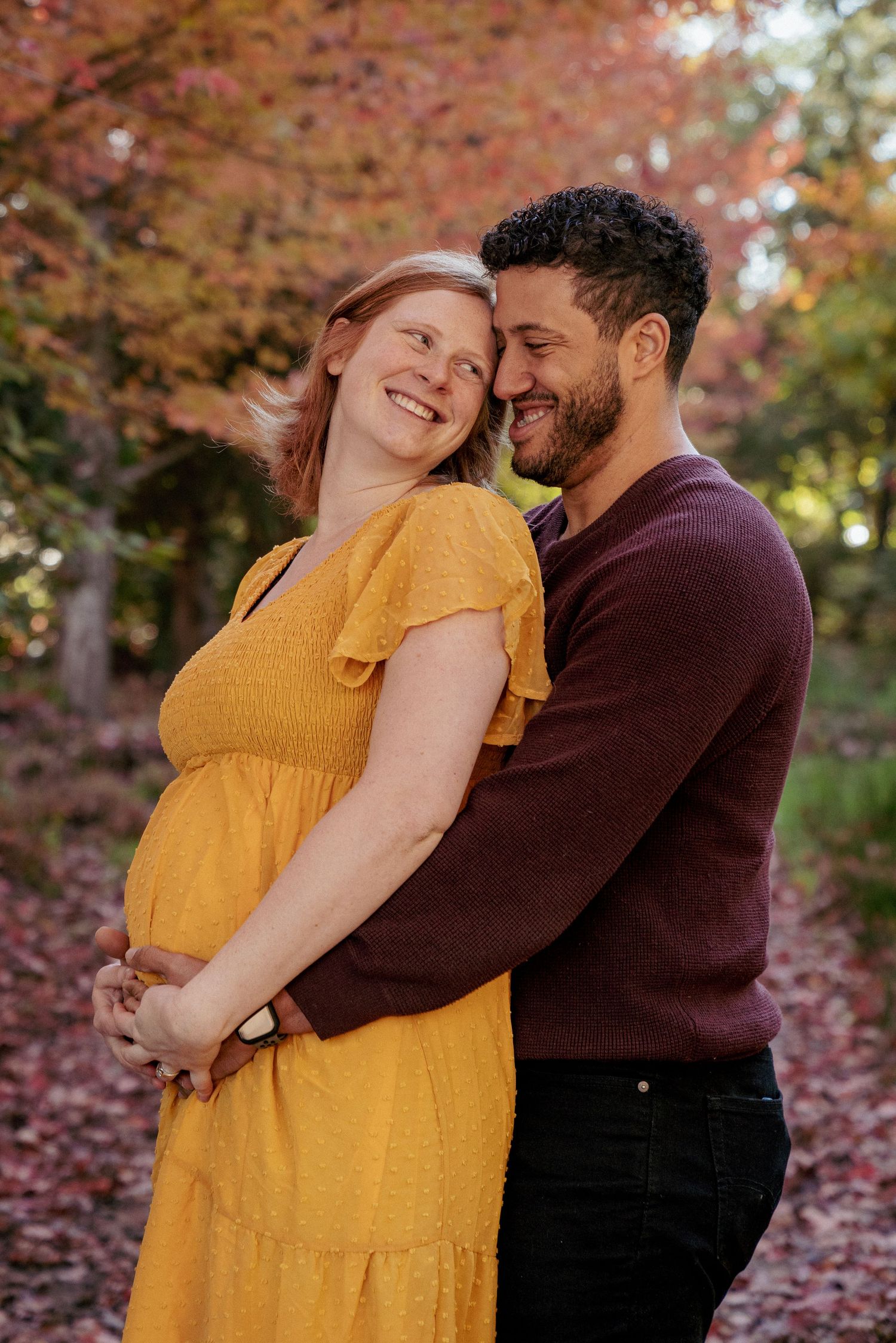 Warm and cozy maternity hug, couple smiling in fall colors, PNW Oregon maternity session with golden light.