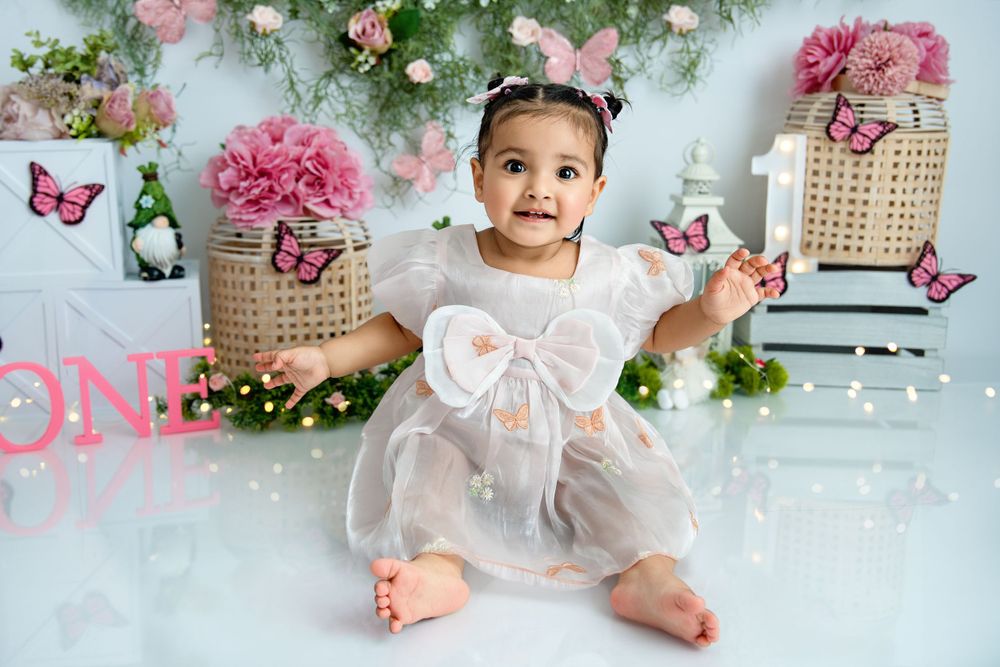 Dreamy floral photography setup with pink flowers, butterflies and soft lighting.