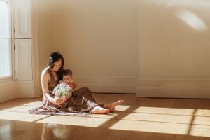 Warm sunlight streams through windows onto a cozy reading nook with books and pillows.