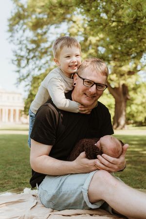 Playful father and child moment captured in a sunny park setting.