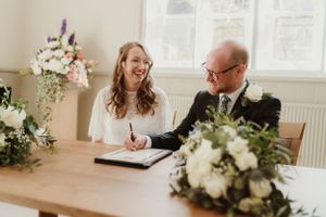 Wedding ceremony moment with floral decorations on signing table.