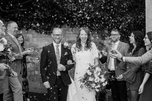 Joyful wedding celebration with confetti being thrown outside.