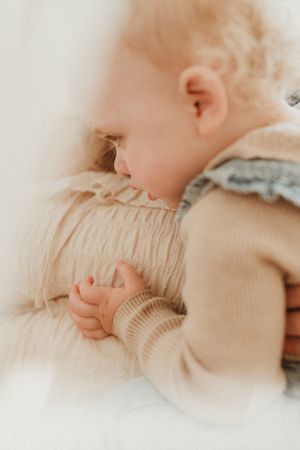 Soft focus close-up of baby sleeping peacefully in neutral tones.