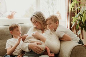 Casual family lifestyle scene on comfortable gray couch with natural window light.