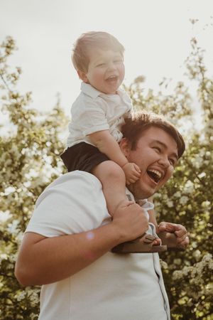 Playful outdoor moment captured in golden sunlight among blooming trees.