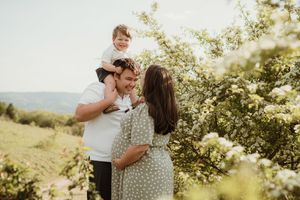 Family enjoying a sunny afternoon in flowering orchard during spring.