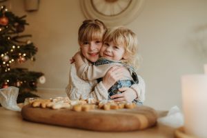 Mother and child baking cookies together during holiday season.