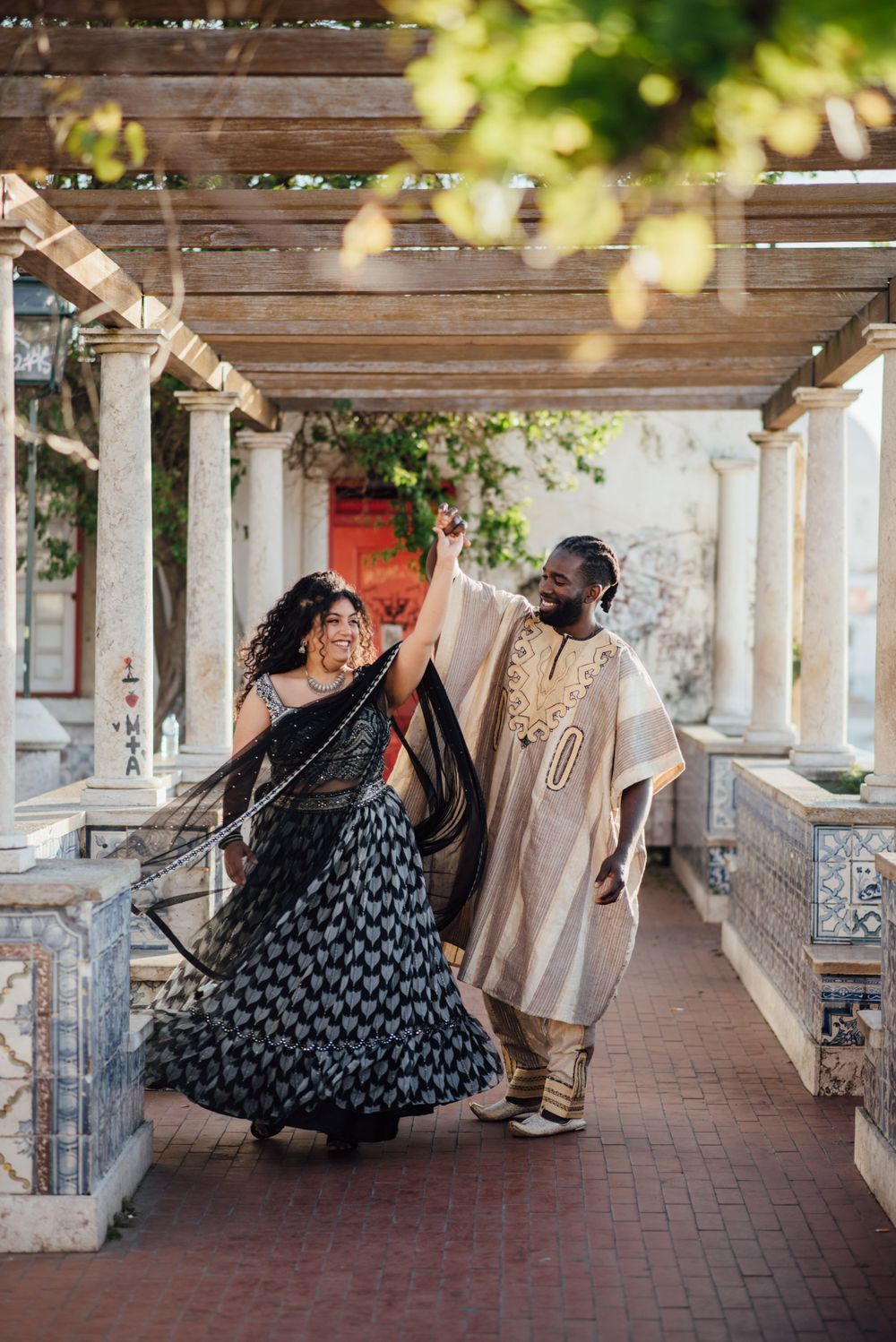lisbon love story photo session at Miradouro Santa Luzia showing indian couple dancing.
