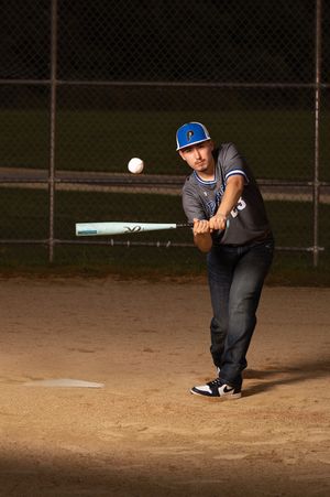 A sequence of baseball bunting technique shown in four progressive action shots on a dirt infield at night.