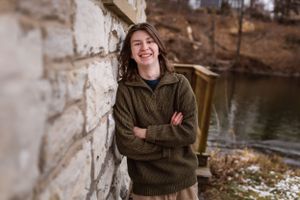 Person in green sweater stands laughing with arms crossed by stone wall near water.
Janesville, WI
Brodhead, WI