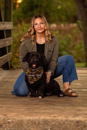 A person in casual attire sits on a wooden deck with a small black dog in a series of outdoor portrait shots.