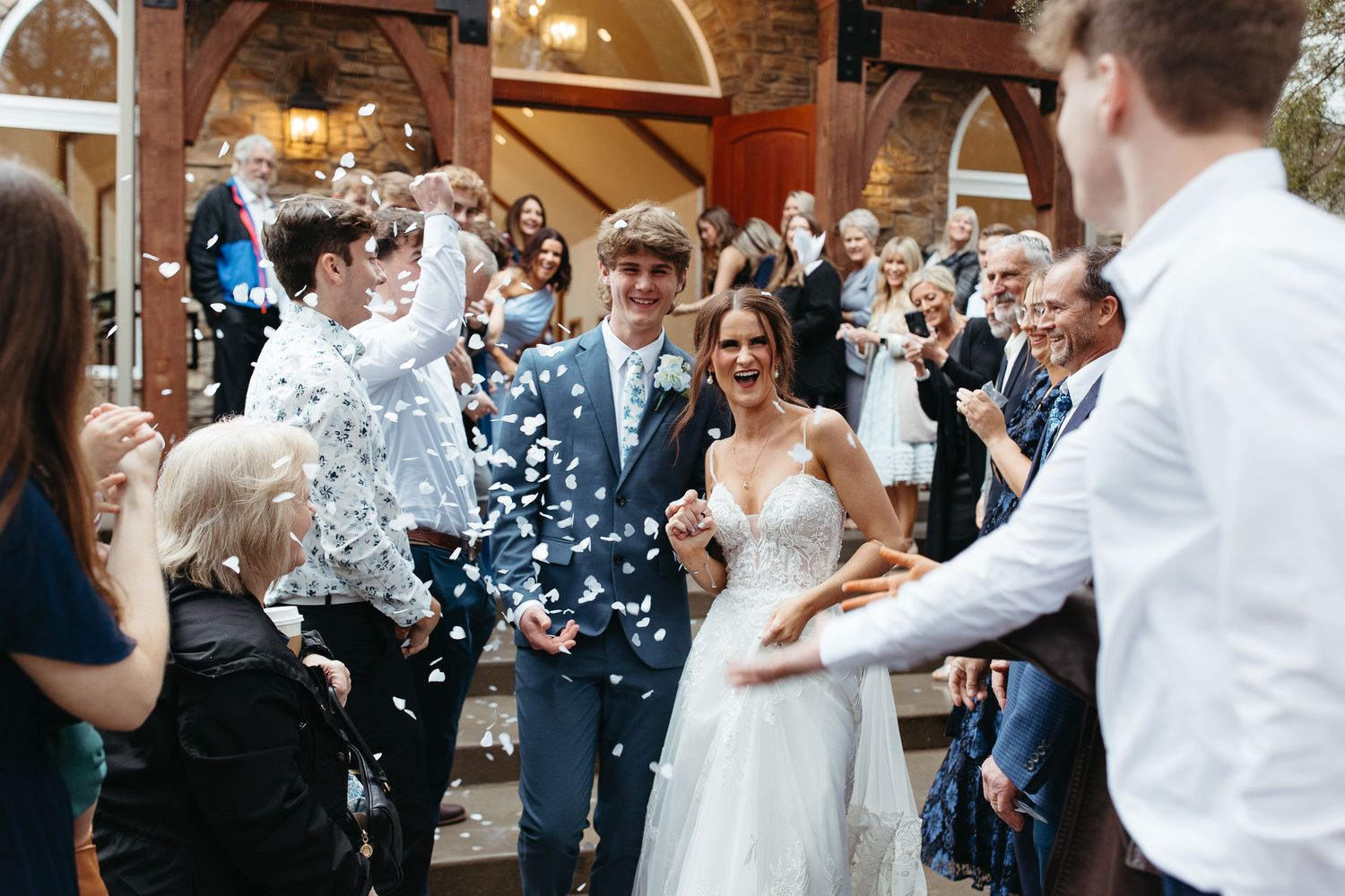 Wedding celebration with confetti being thrown at newlyweds in an elegant indoor venue.