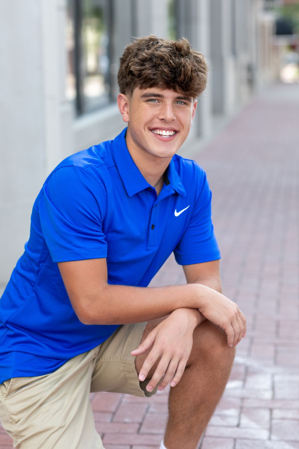 Casual outdoor portrait wearing bright blue Nike polo and khaki shorts.