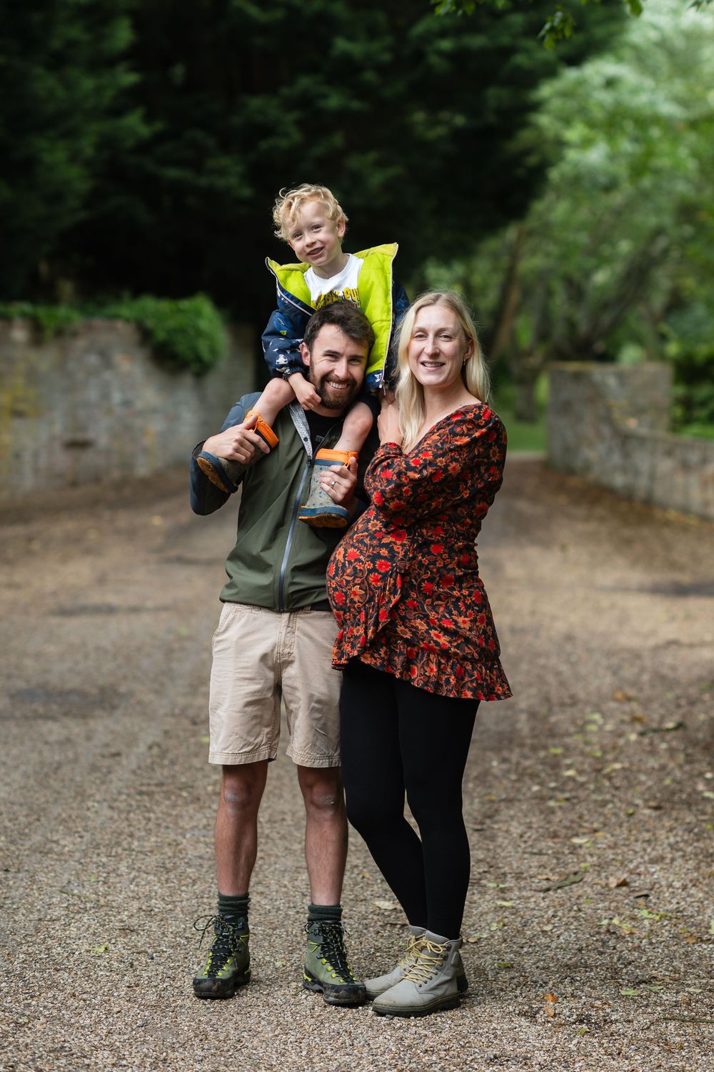 Two people pose together outdoors on a gravel path showing playful expressions and gestures.