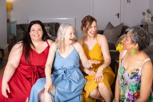 Friends sharing laughter while sitting together at a social gathering.