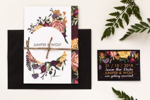 Elegant wedding stationery suite featuring floral designs and black accents with a fern leaf accent.