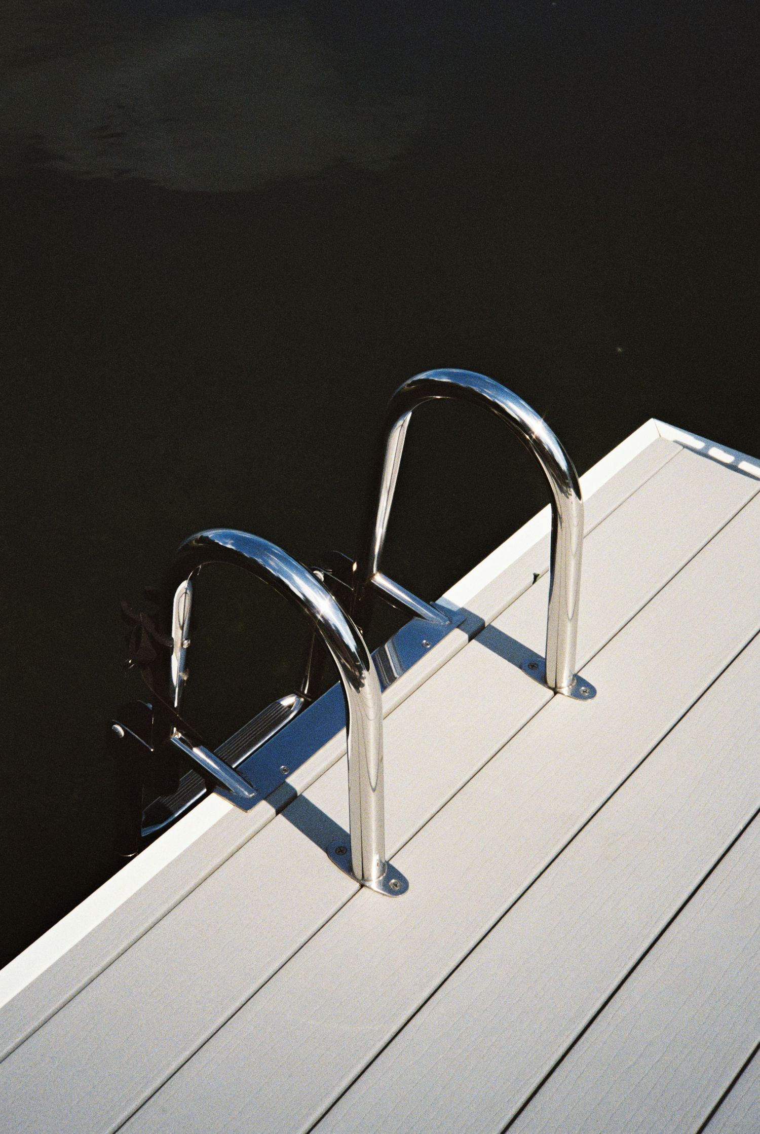 Beach directional signs for swim and surf areas against a clear blue sky.