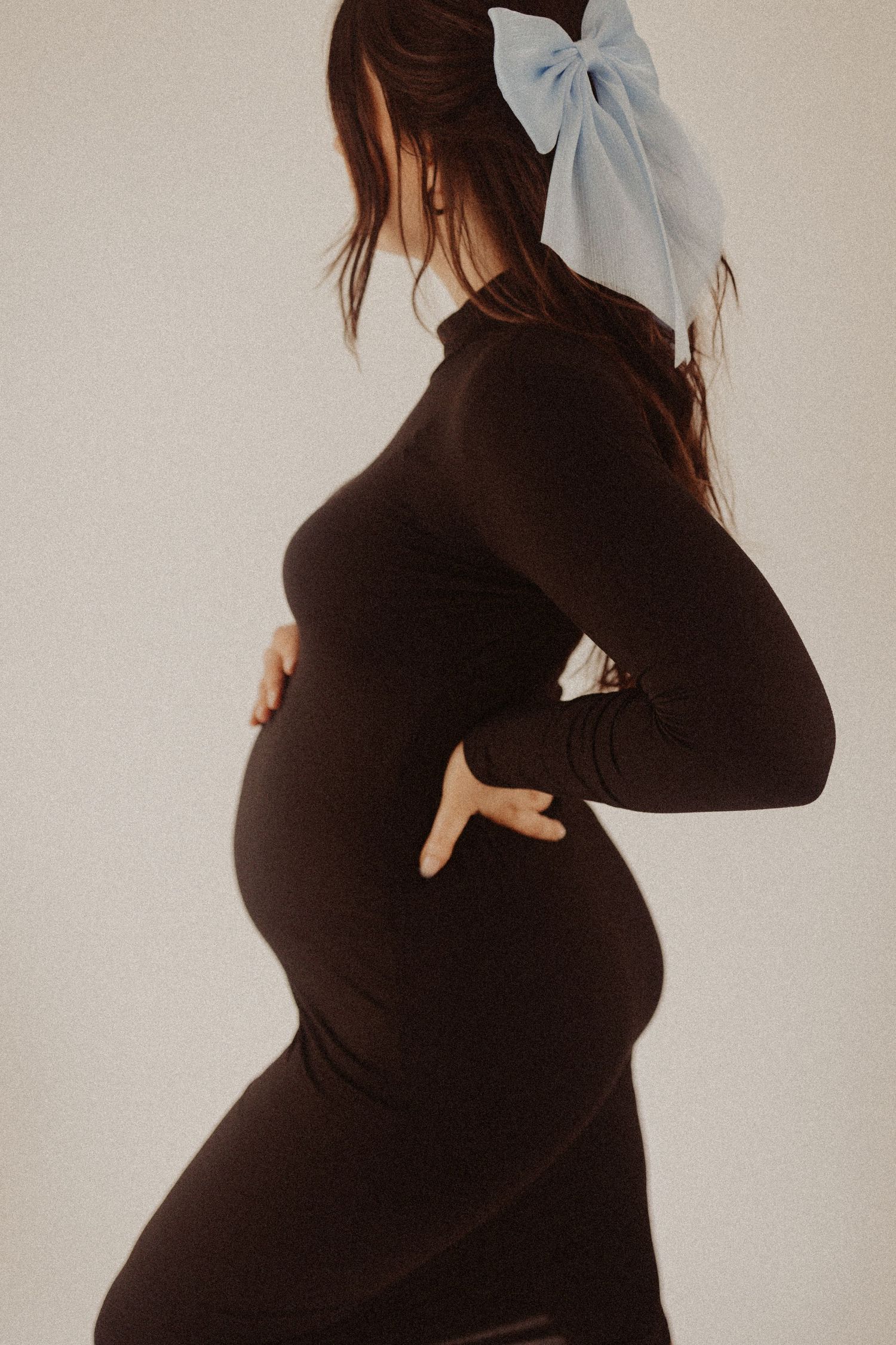 showing off the bow during maternity photography session