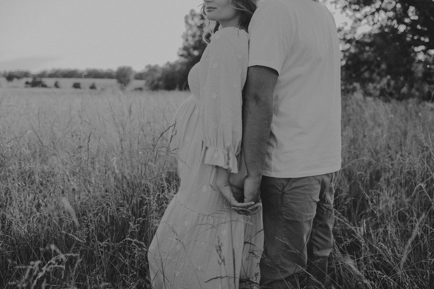 mom and dad in a field for maternity session