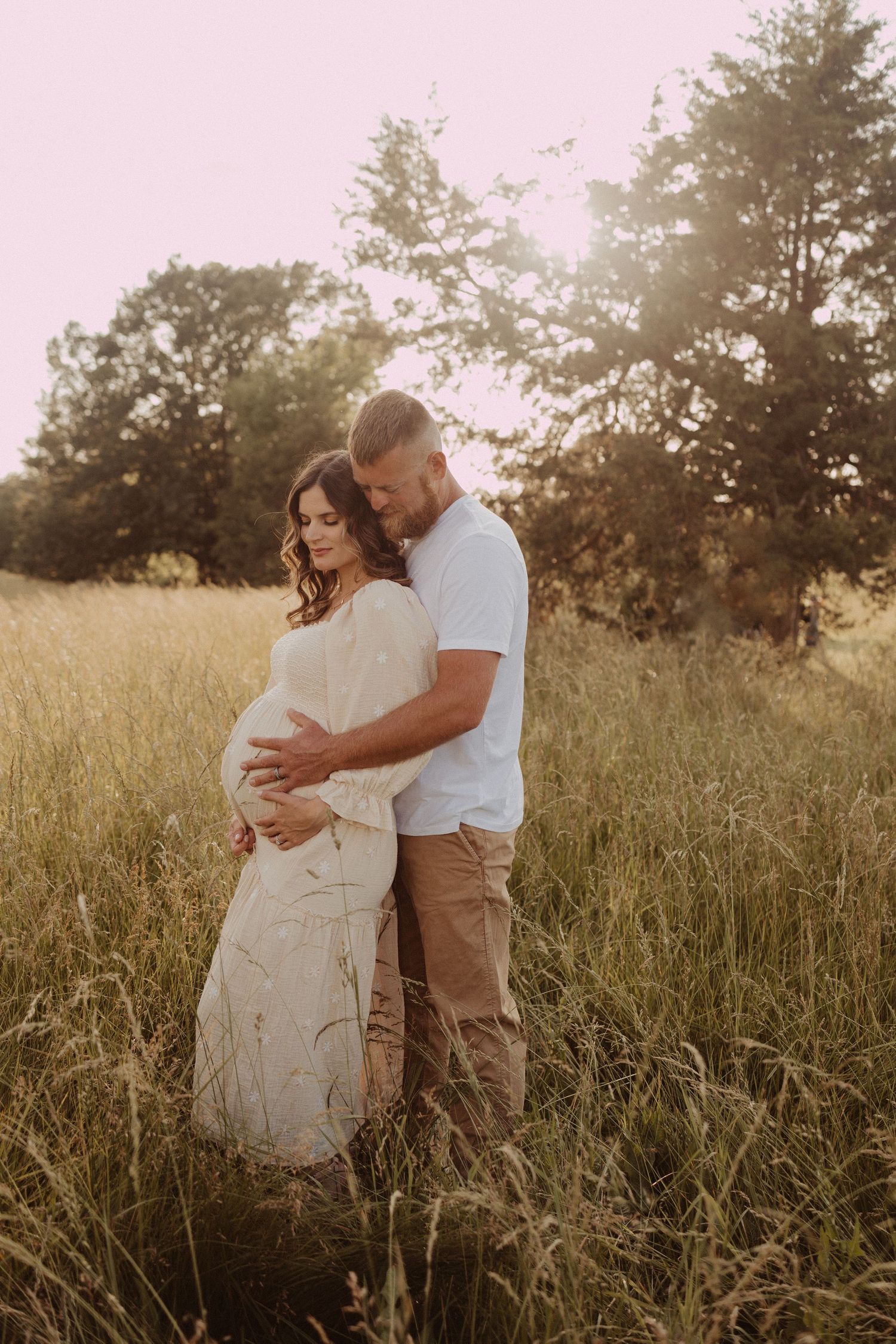 looking at their growing baby bump in the field- maternity photography