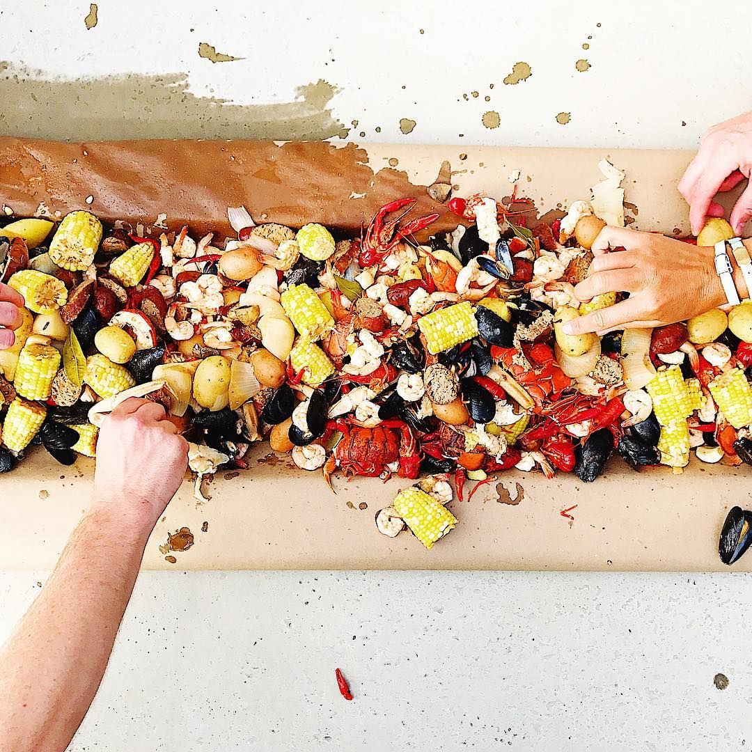 Colorful chopped vegetables and ingredients arranged in a line on a wooden cutting board.