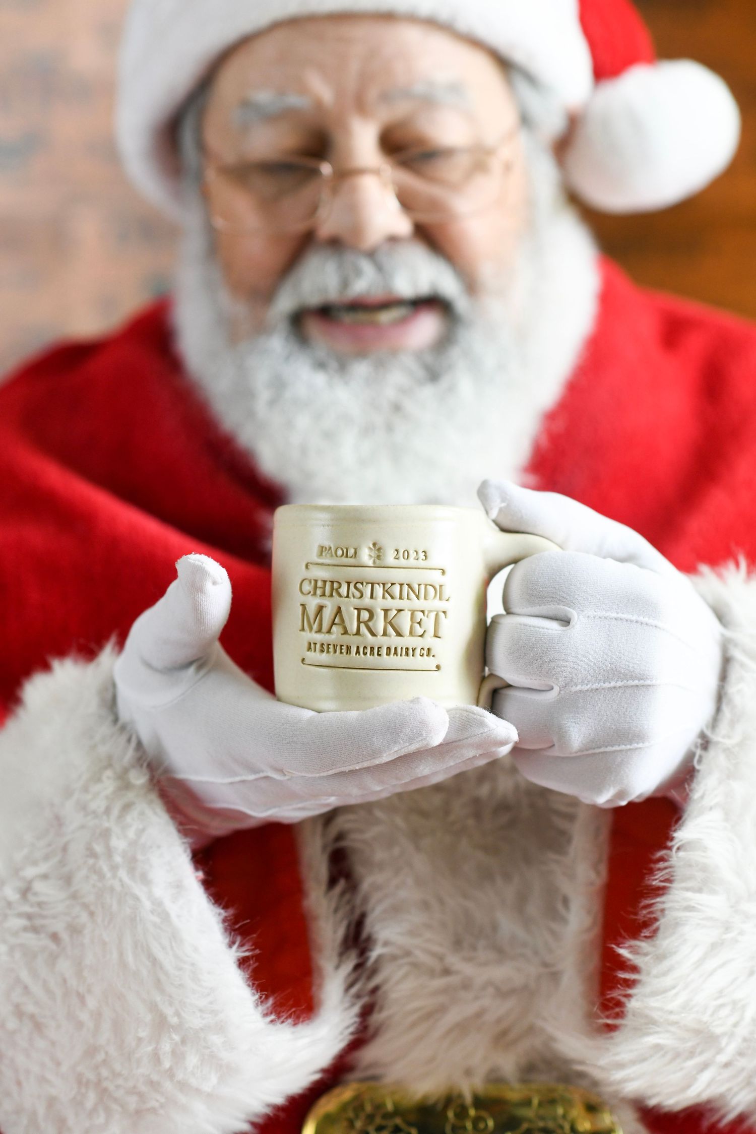 Holiday-themed ceramic mug showcasing 'Christmas Market' text held against seasonal decorations.
