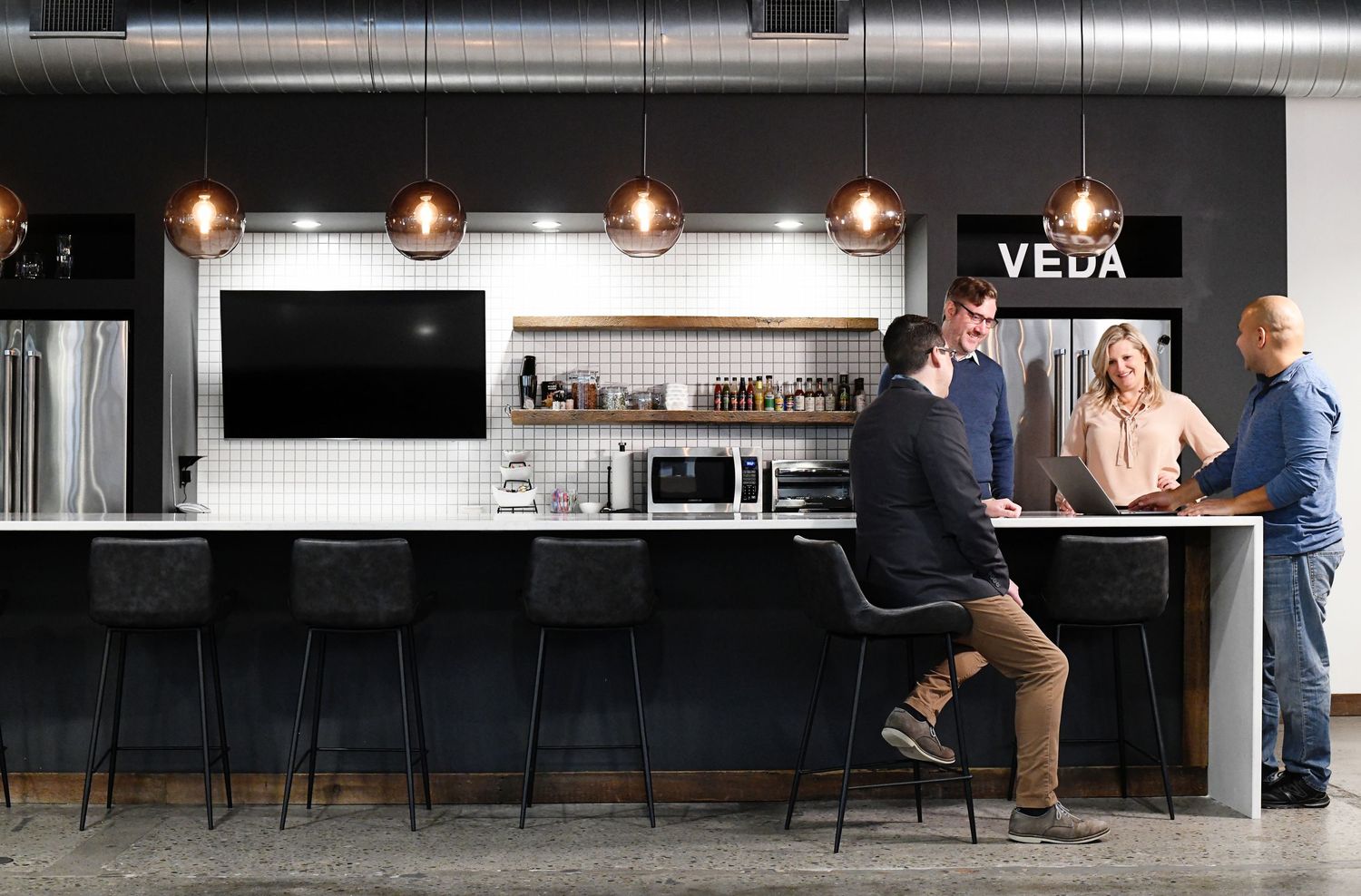 Modern bar interior with pendant lighting and counter seating at Vela establishment.