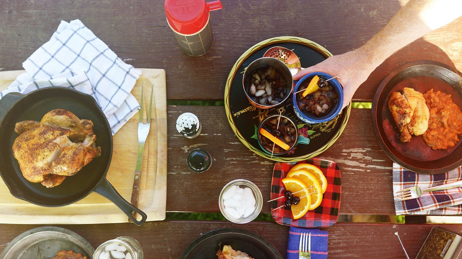 Overhead view of various dishes and plates arranged on a rustic wooden table.