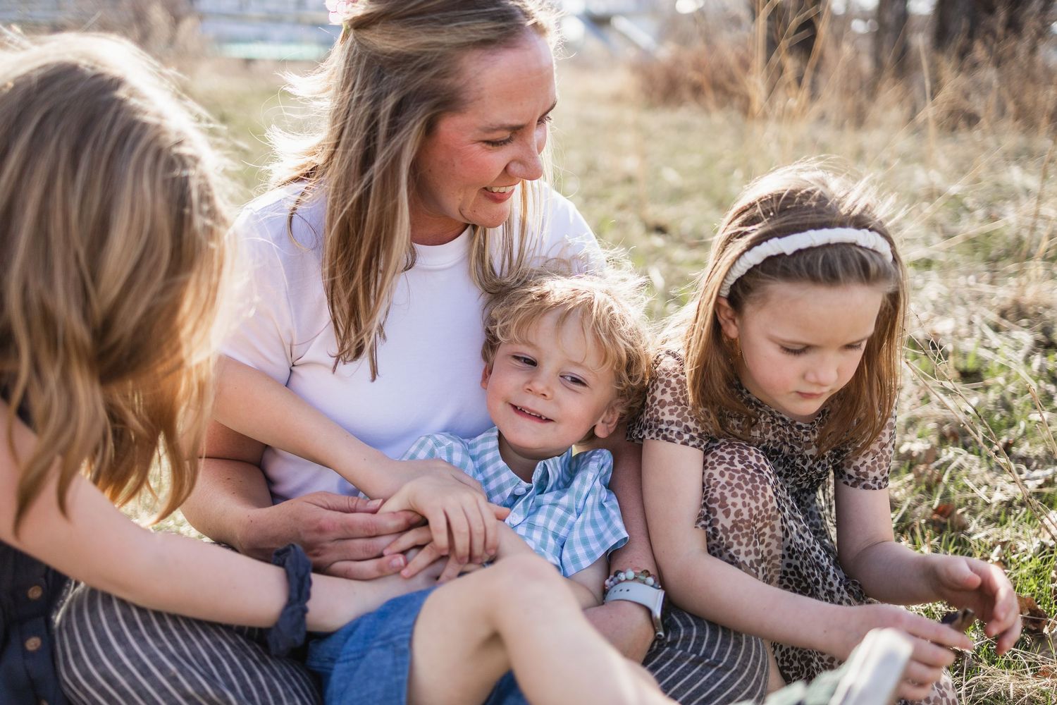 A mother and her children sit together on a beautiful spring evening