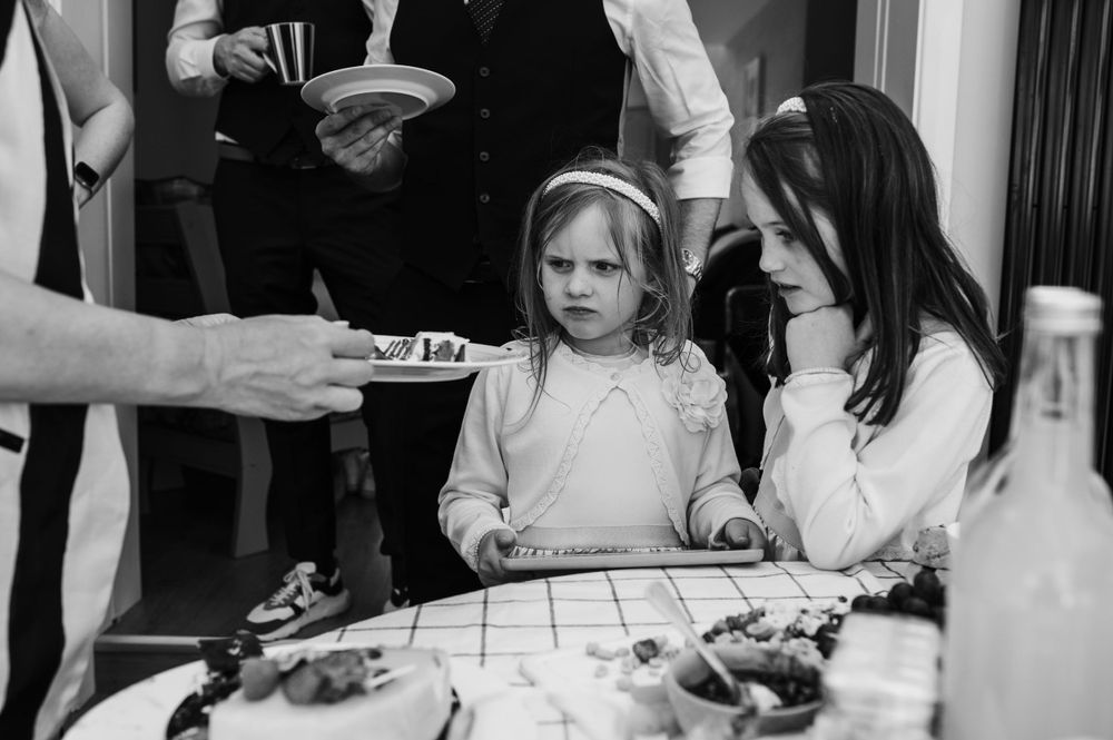 A black and white photo of people gathered around a table at a celebration.