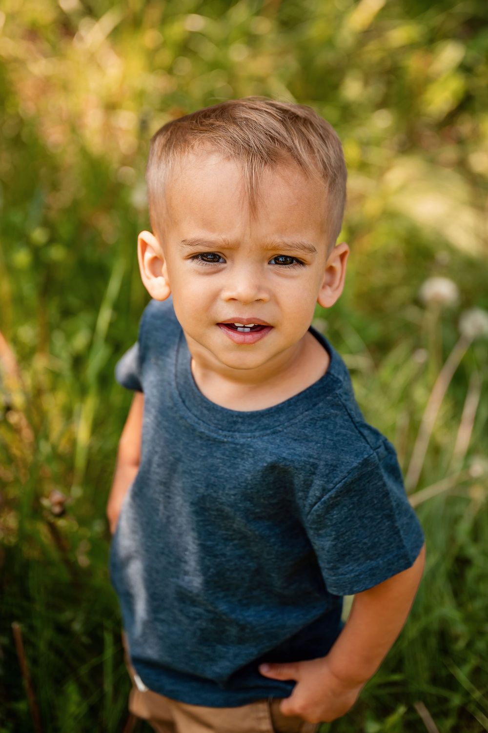A series of candid photos shows a child wearing a navy blue t-shirt playing outdoors in natural lighting.