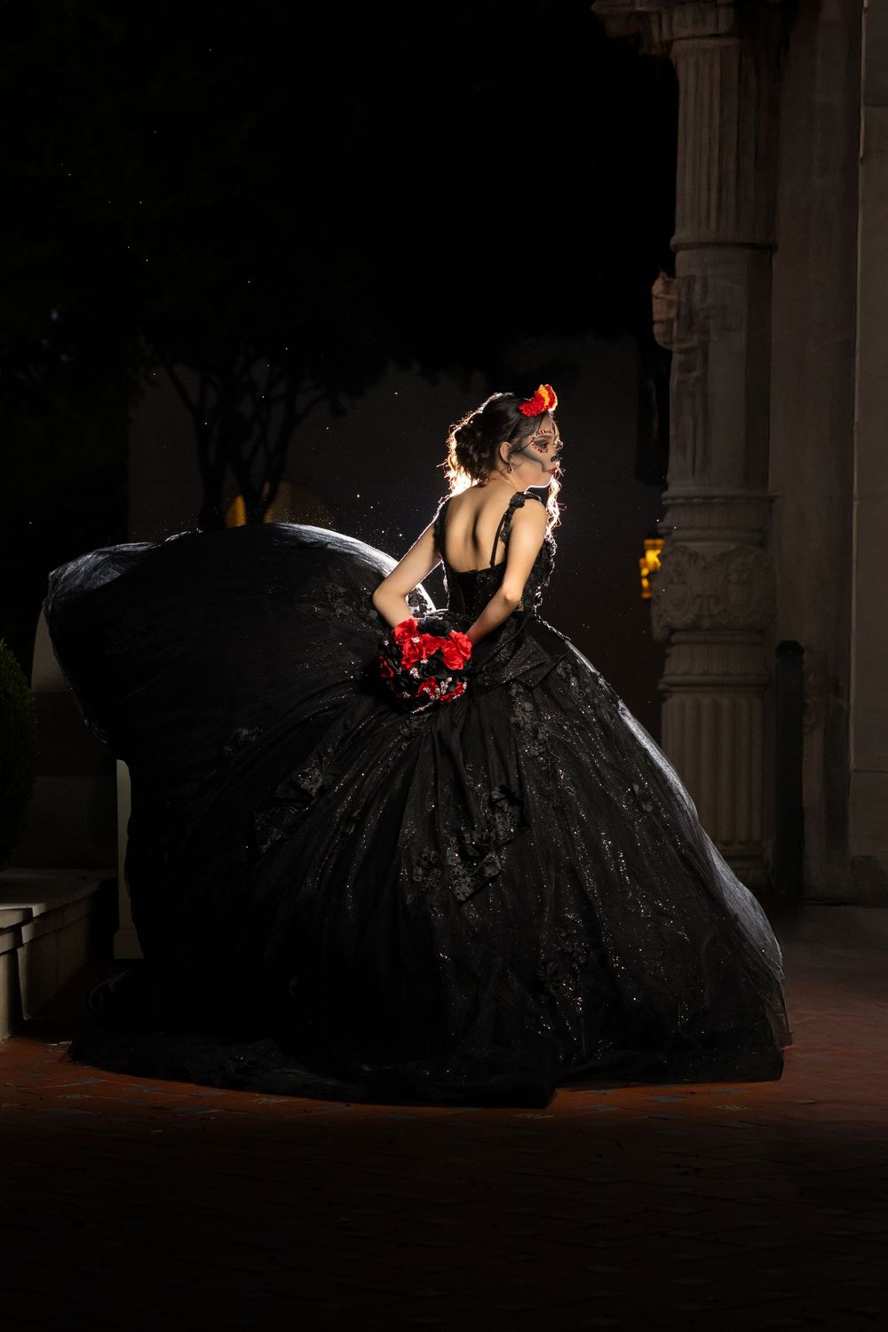 Dramatic portrait series of woman in black ballgown against dark background.