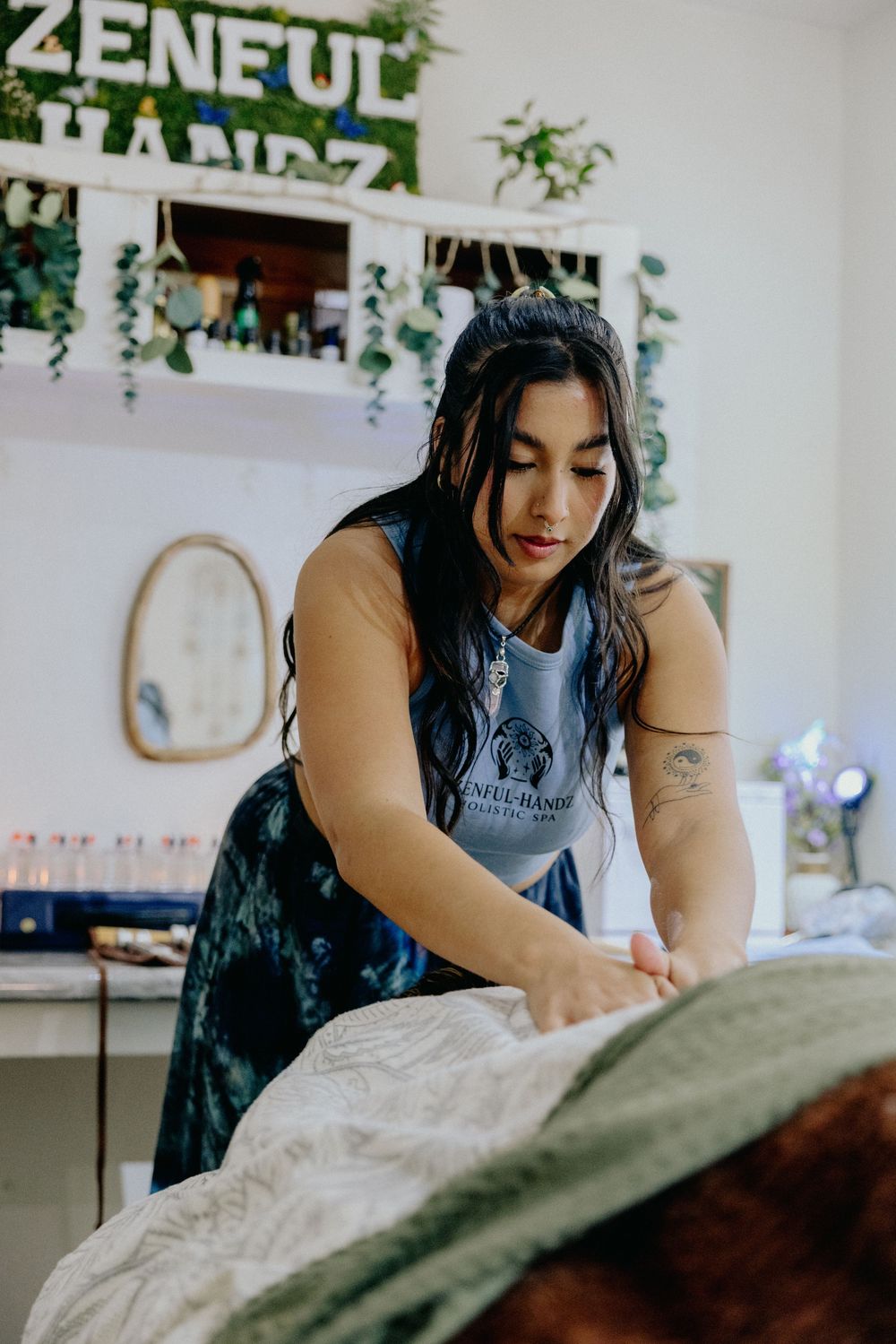 Licensed massage therapist at Zenful Handz Holistic Spa providing professional bodywork on a massage table.