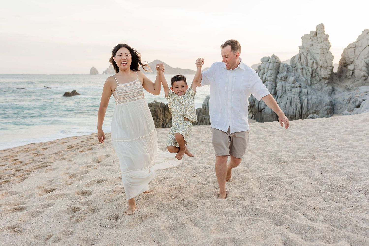 Family walking together on Los Cabos beach at sunset