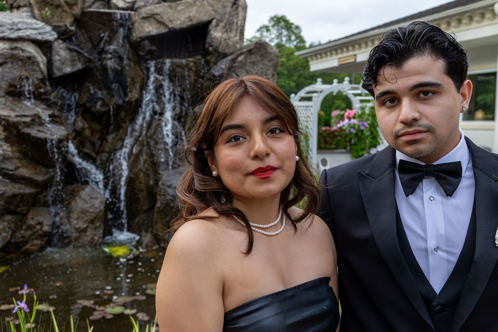 Formal event photography capturing elegant attire against a natural rock garden backdrop.