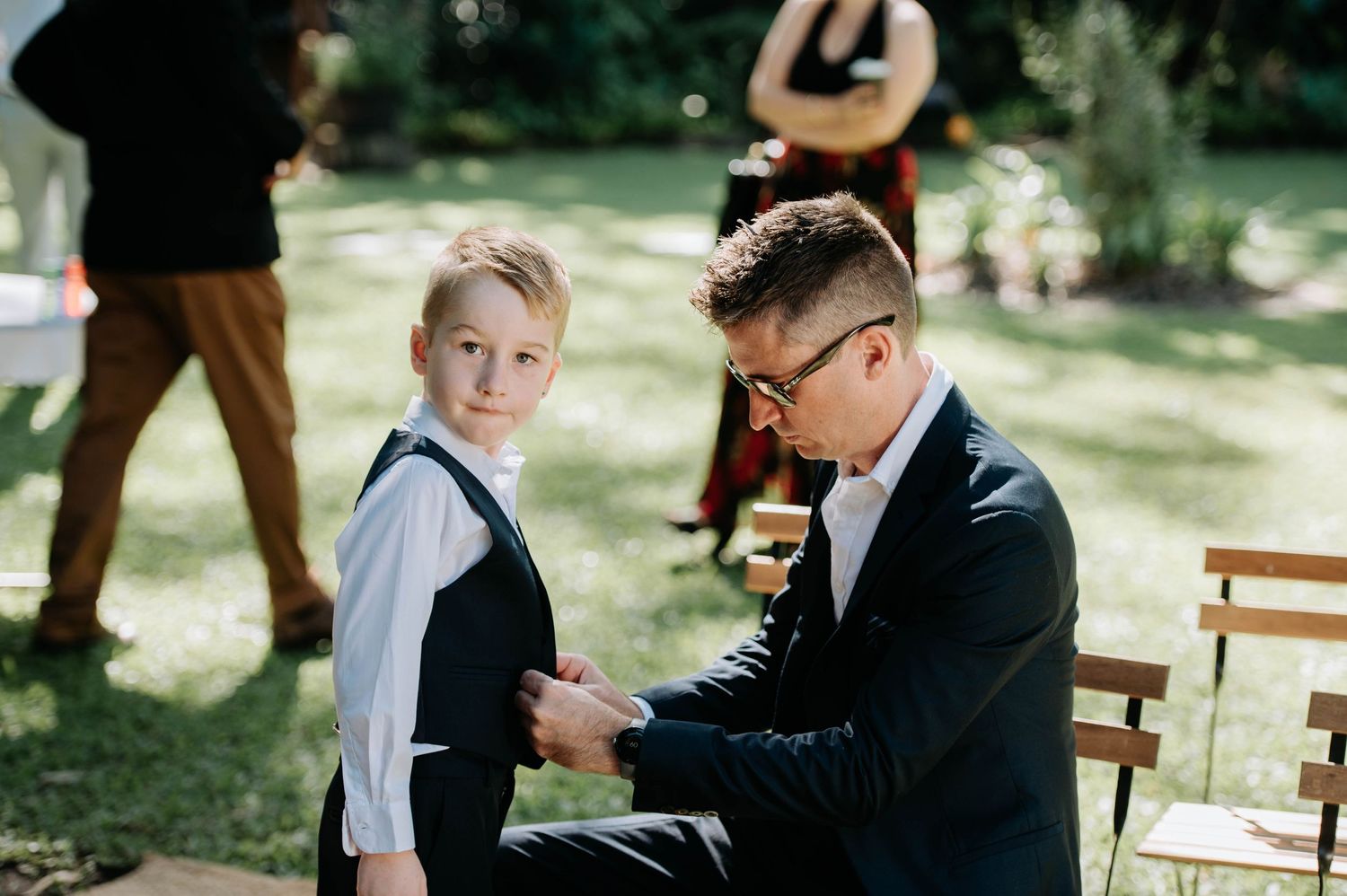 A touching moment between two people during an outdoor garden wedding ceremony.