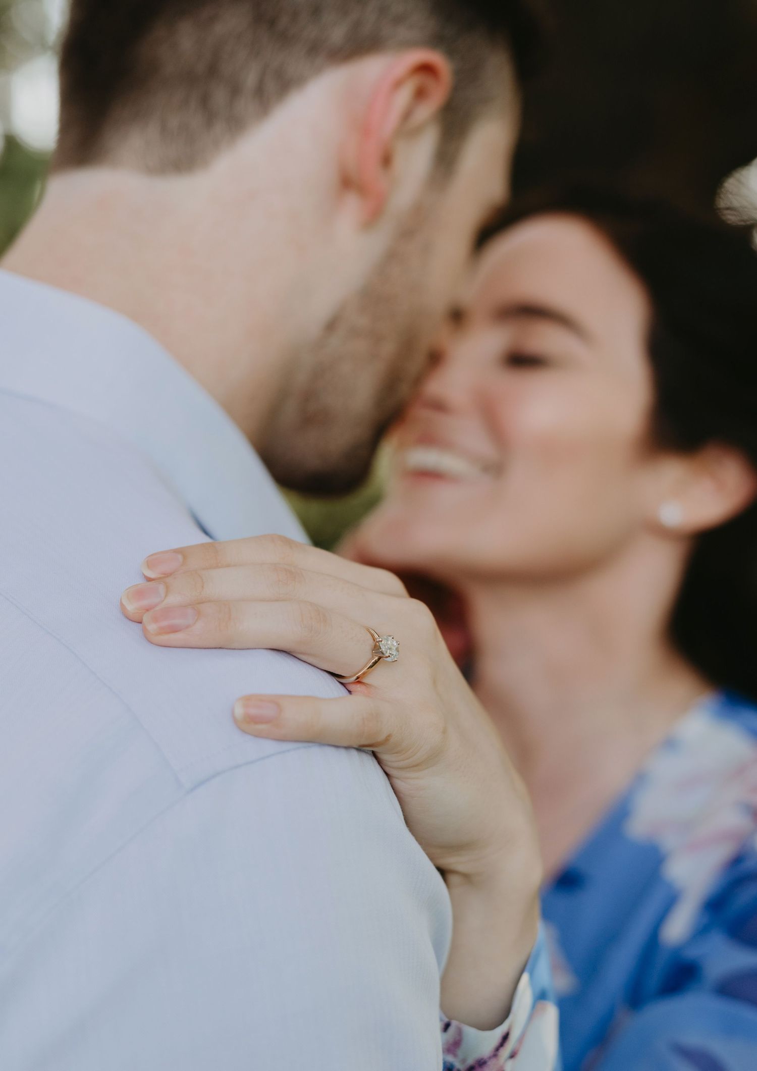 Close-up shot showing hands and an engagement ring during an intimate moment.