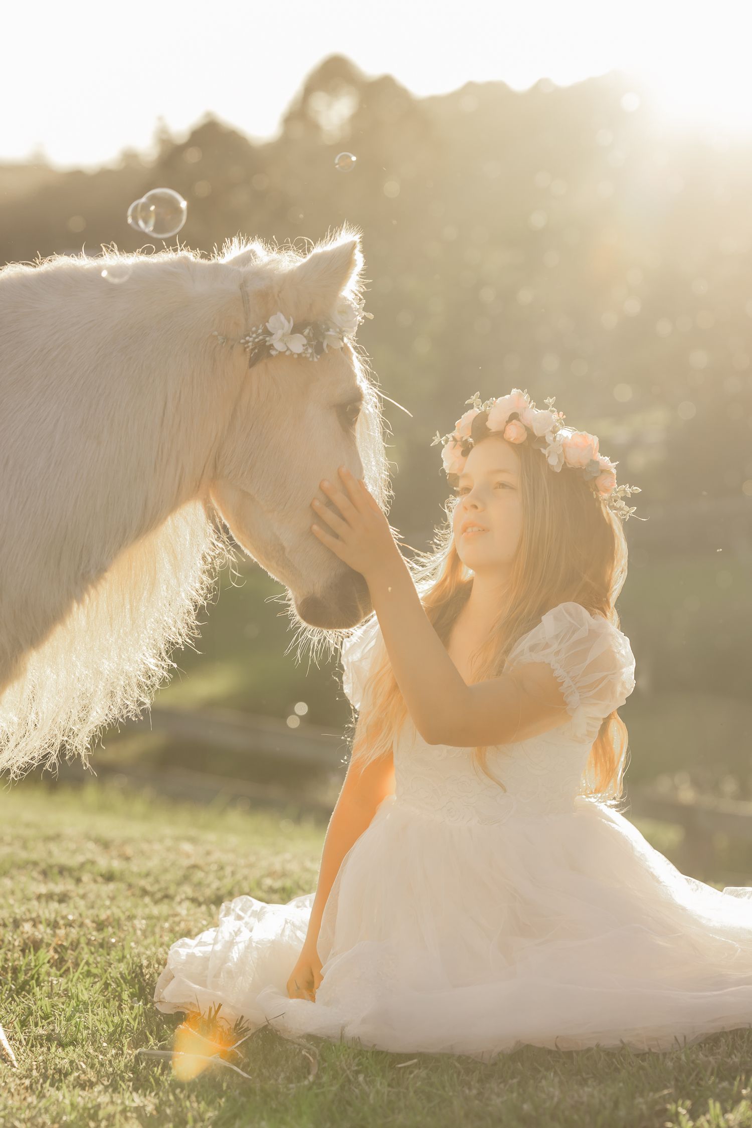 Dreamy sunlit scene with flowing white dress and floral crown in a grassy field.