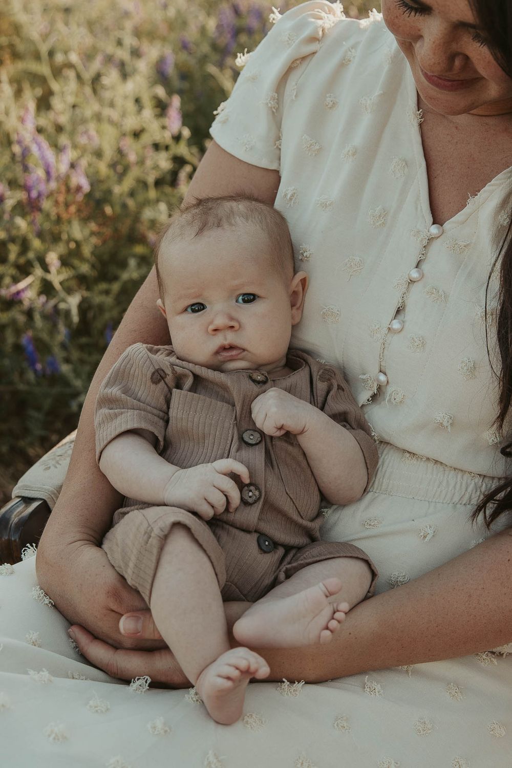 close up of baby while being held by mom in white dress by spokane family photographer