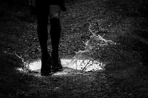 Black and White, runners feet splashing in a puddle