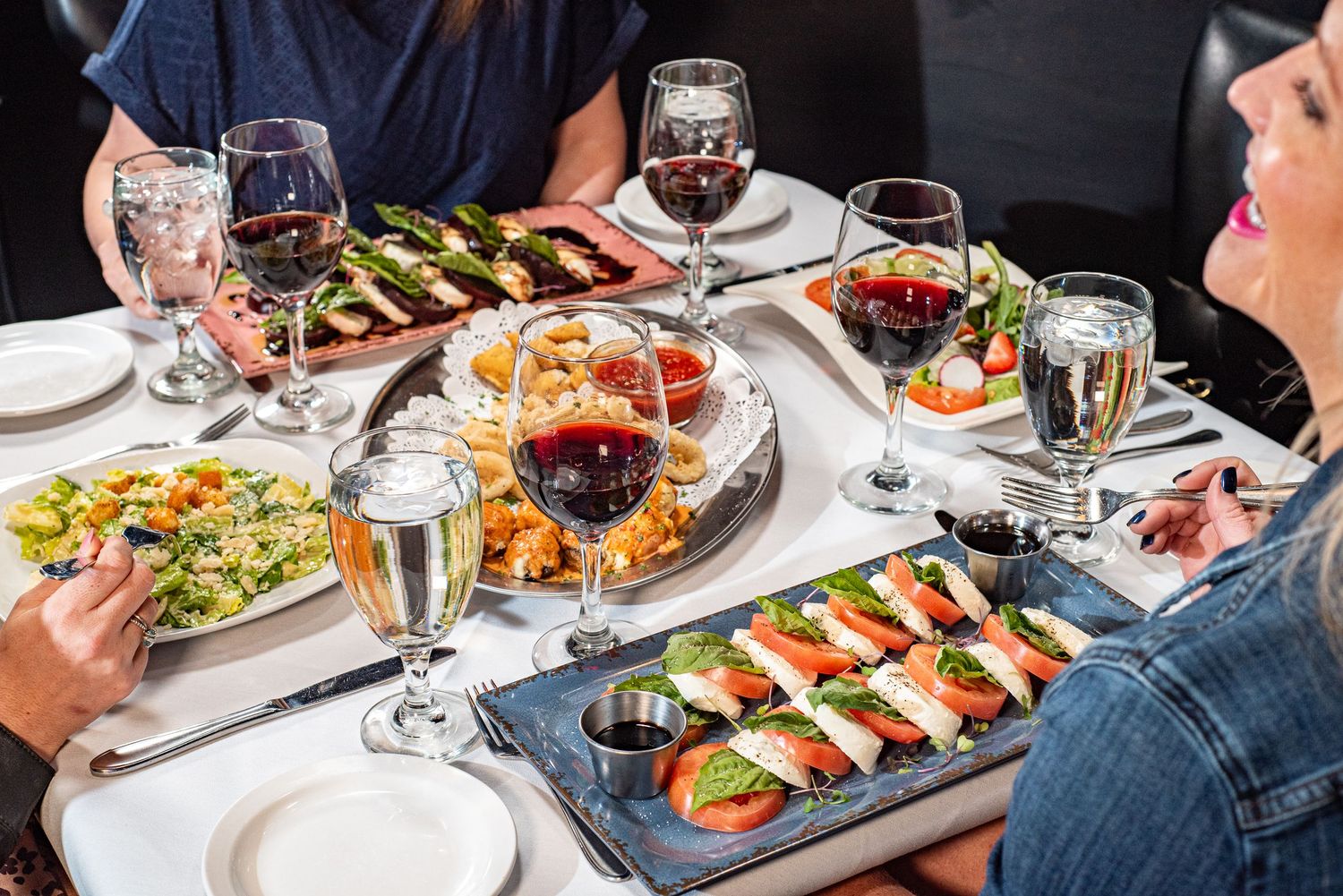 A dinner table with different types of Italian food found at La Bistro Italian Grille in Colleyville, TX.