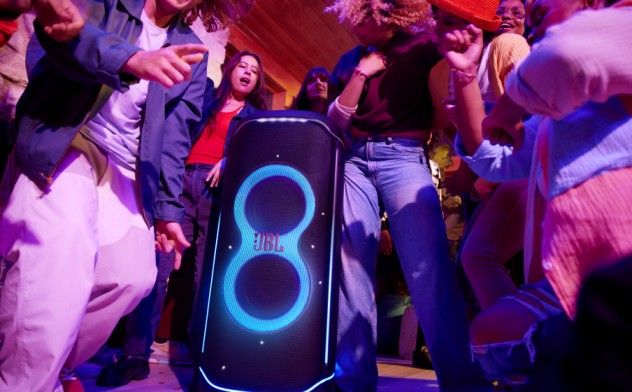 Energetic nightclub crowd dancing under purple lighting at a party event.