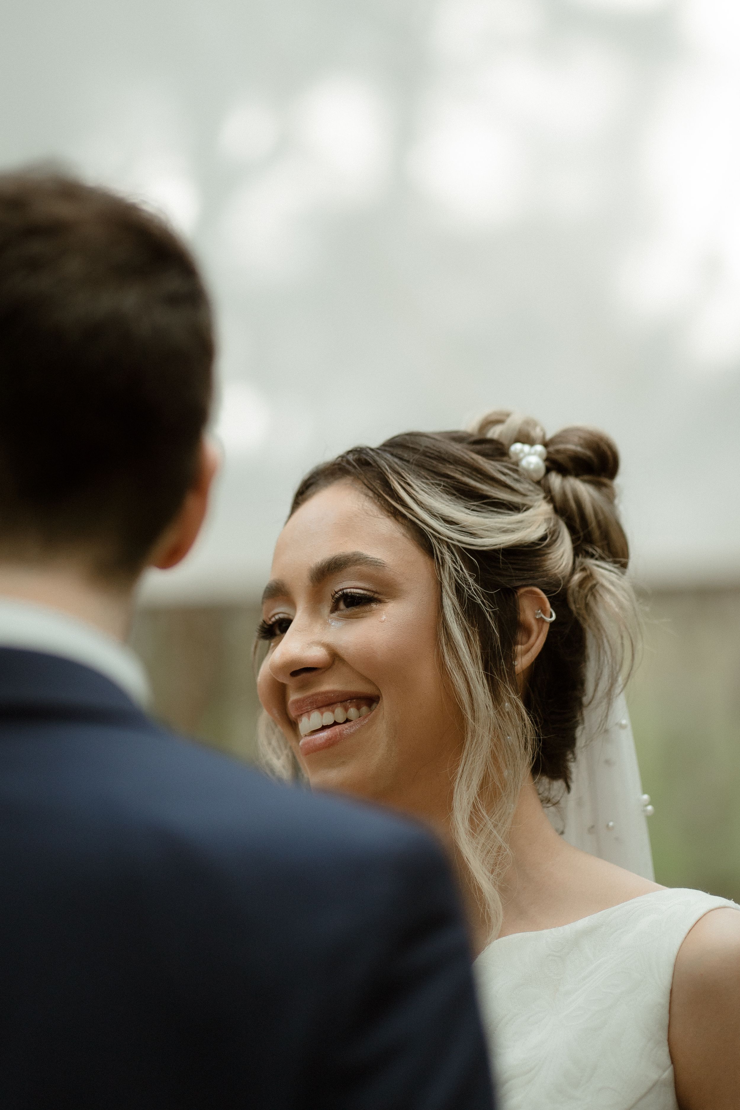A candid wedding moment captured with natural lighting and a soft bokeh background.