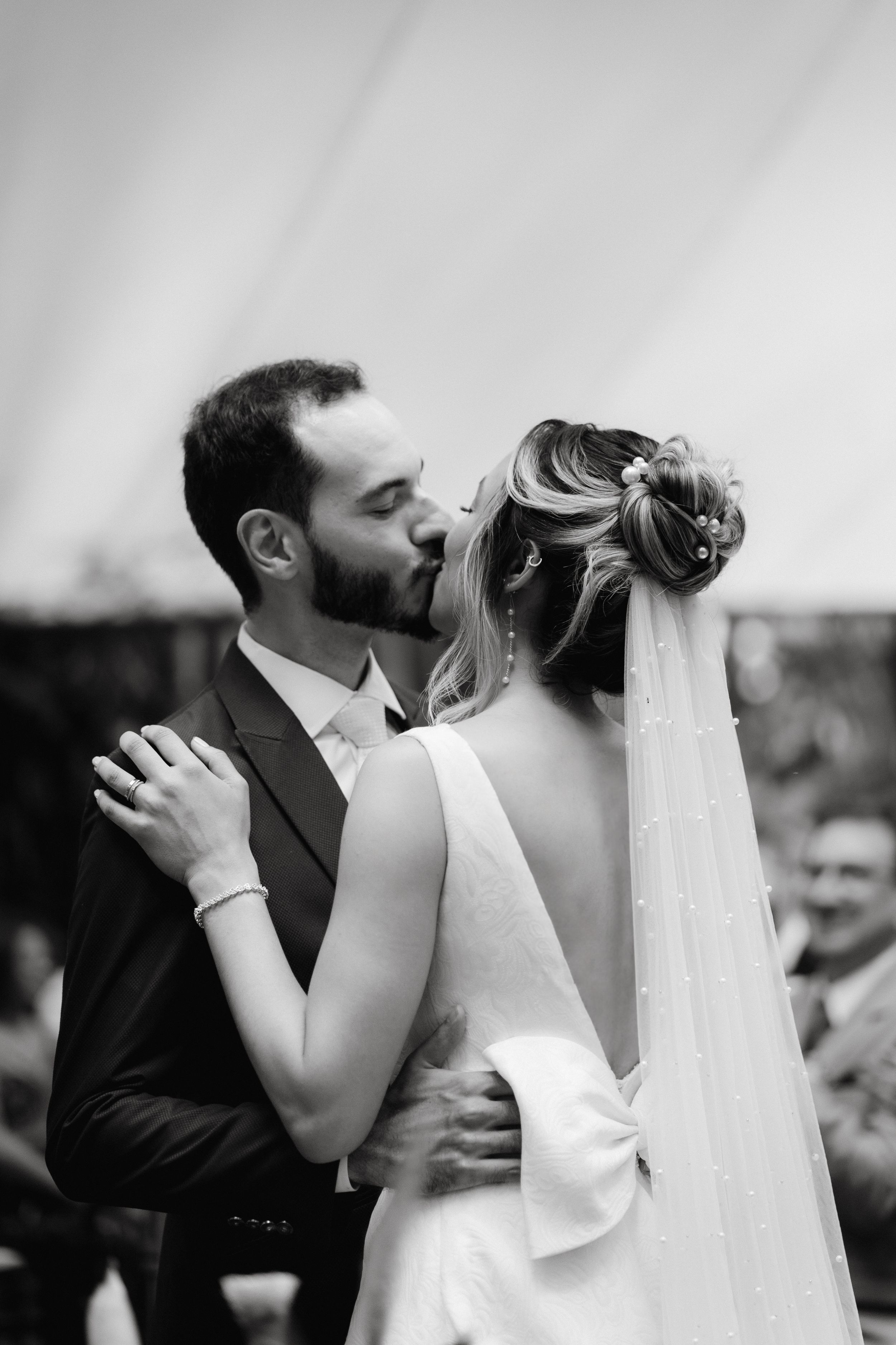 Black and white intimate moment between newlyweds during outdoor wedding ceremony.
