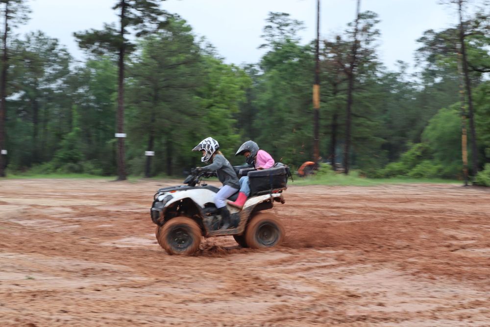 ATV rider navigates through a muddy trail during off-road adventure.