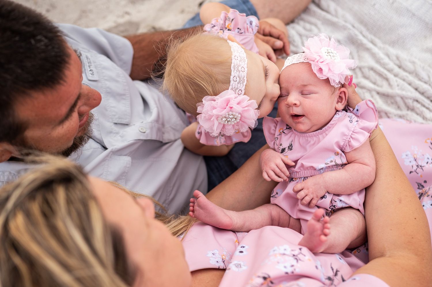 Family photoshoot featuring a mother, father, and a sibling with newborn sitting together  Melbourne Cocoa Vero Florida Brevard County